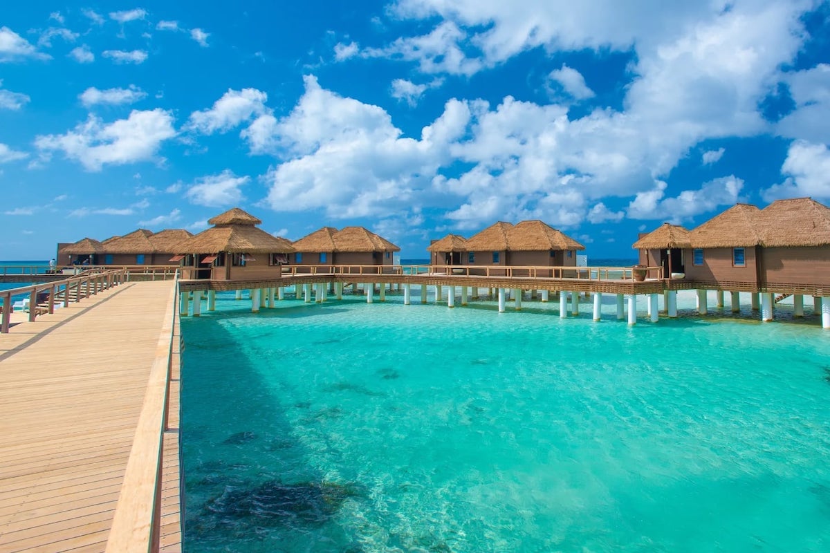 row of overwater bungalows over azure water in Jamaica