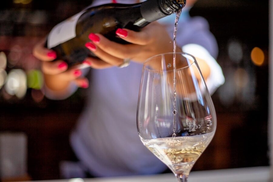 woman pouring glass of white wine