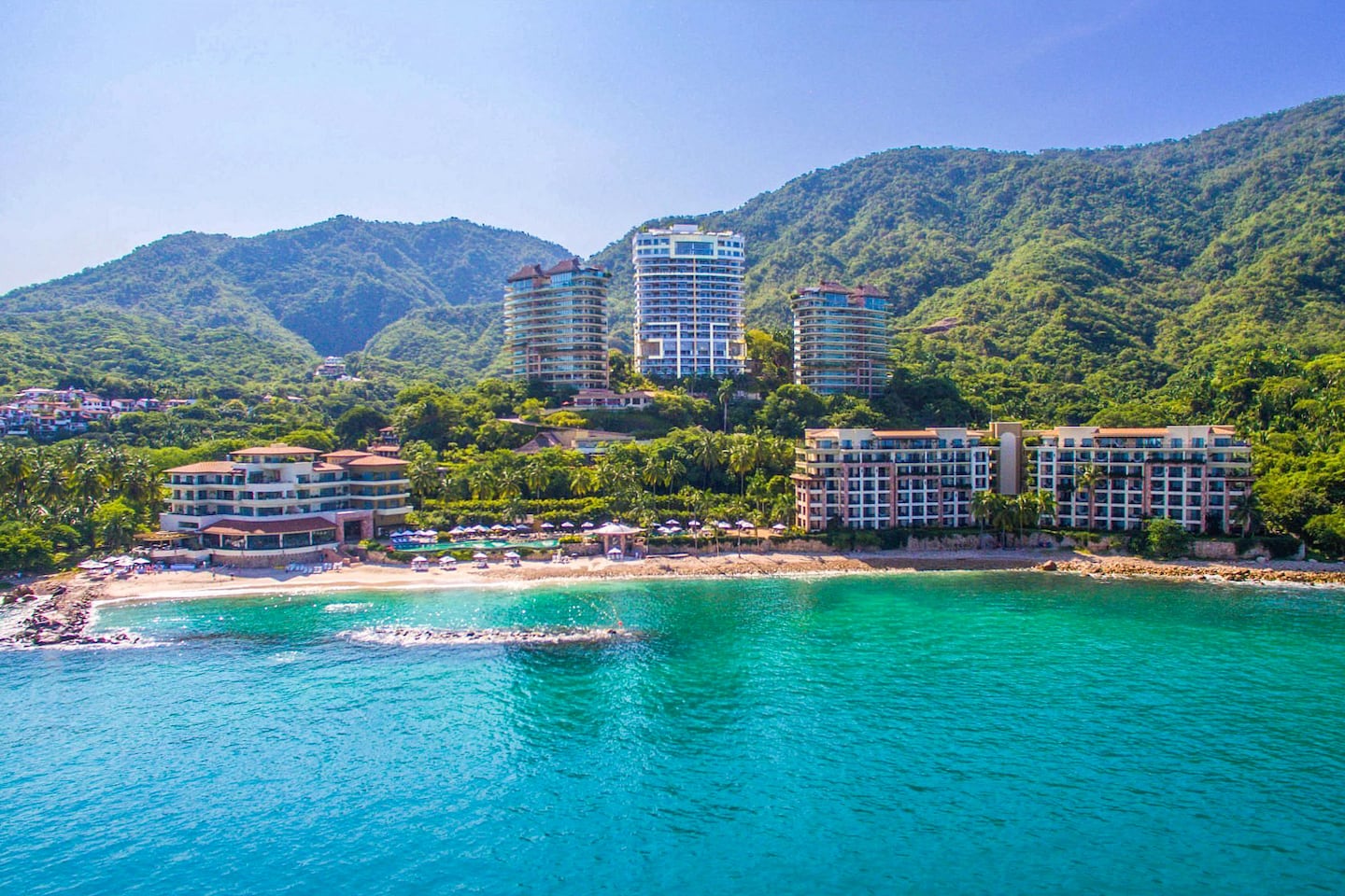 high-rise resort on jungle hill overlooking turquoise ocean